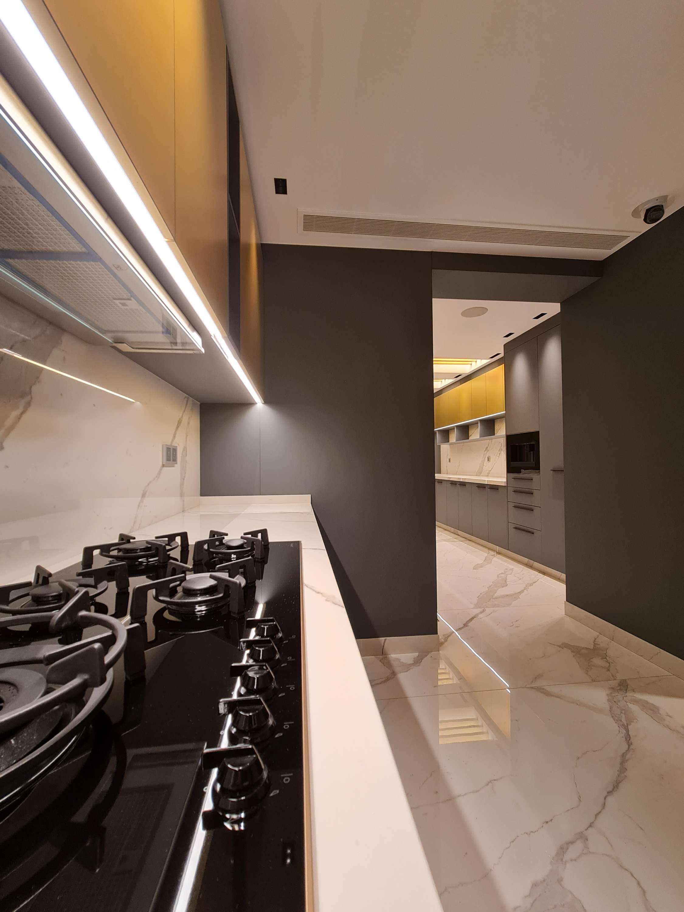 Sophisticated kitchen with marble accents and under-cabinet lighting by La Fabriqua