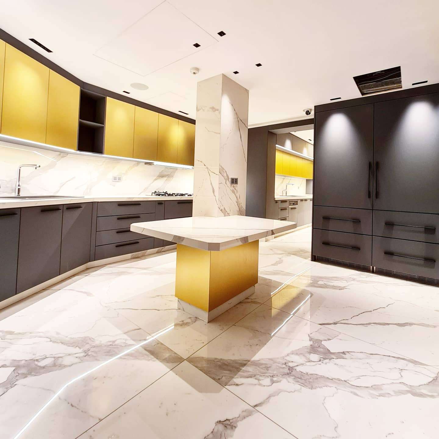 Contemporary kitchen featuring a spacious island and integrated appliances by La Fabriqua