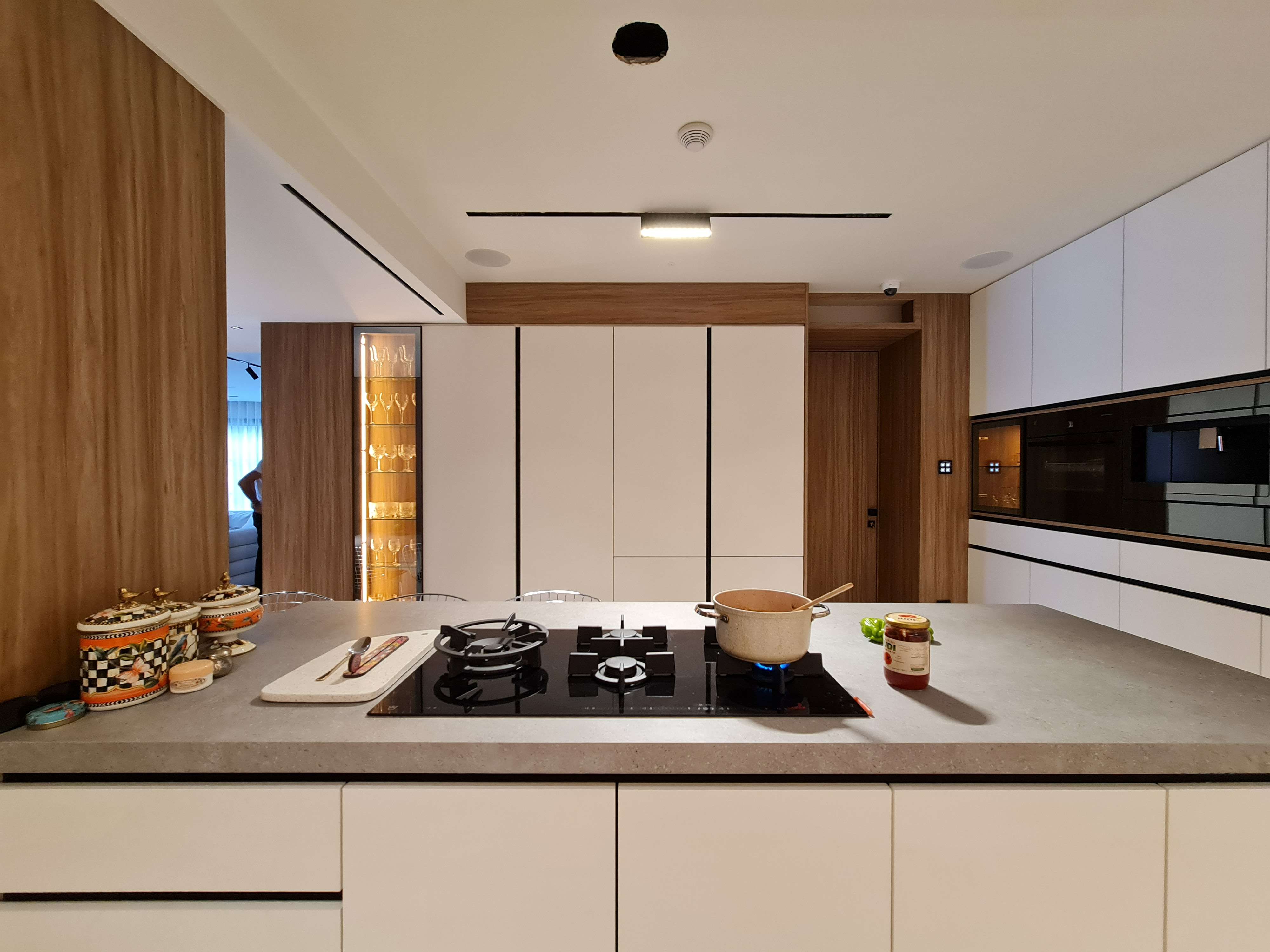 Sleek modern kitchen with a spacious island and premium materials by La Fabriqua