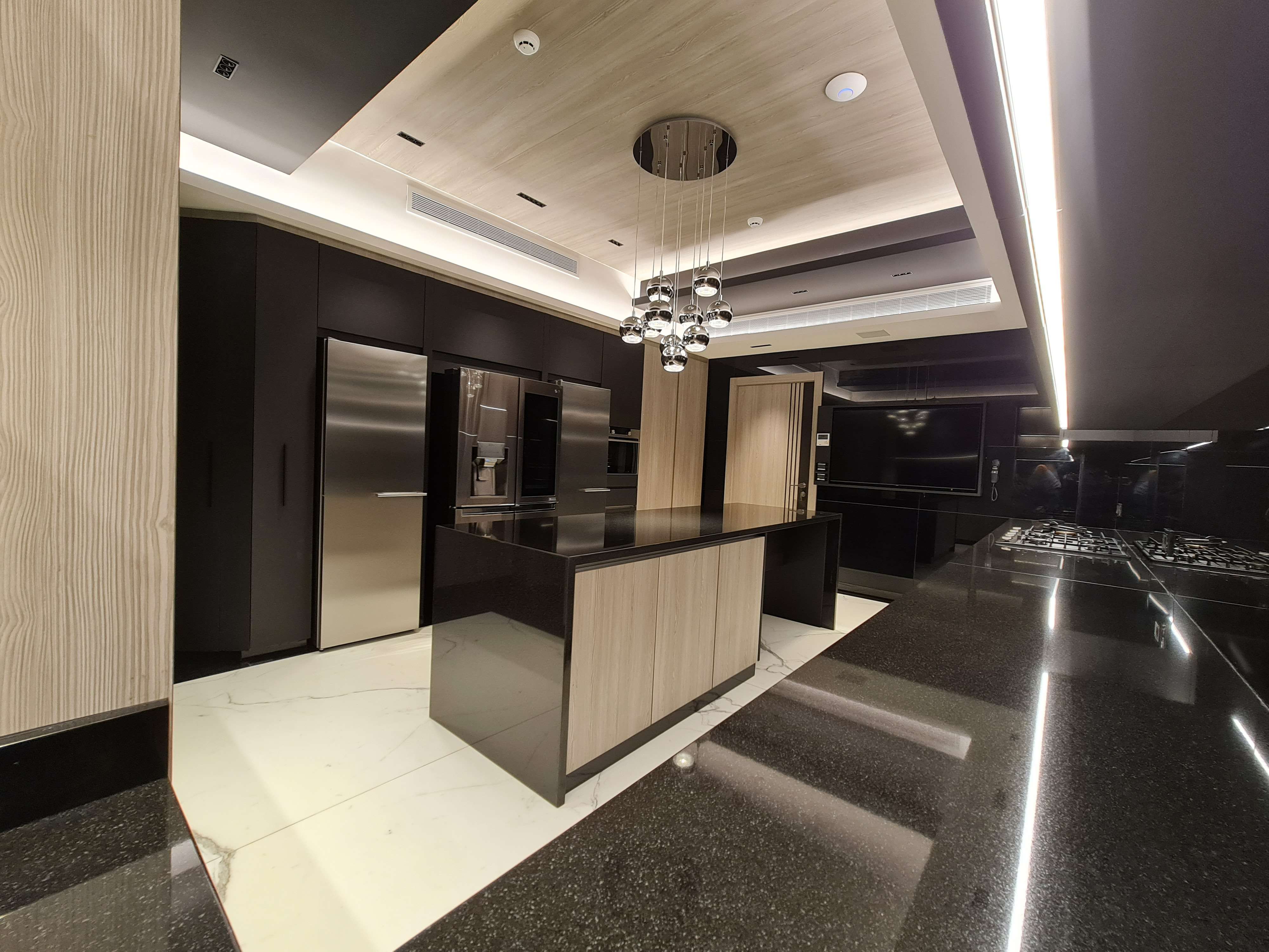 Chic kitchen space with sleek black accents and a stylish breakfast bar by La Fabriqua