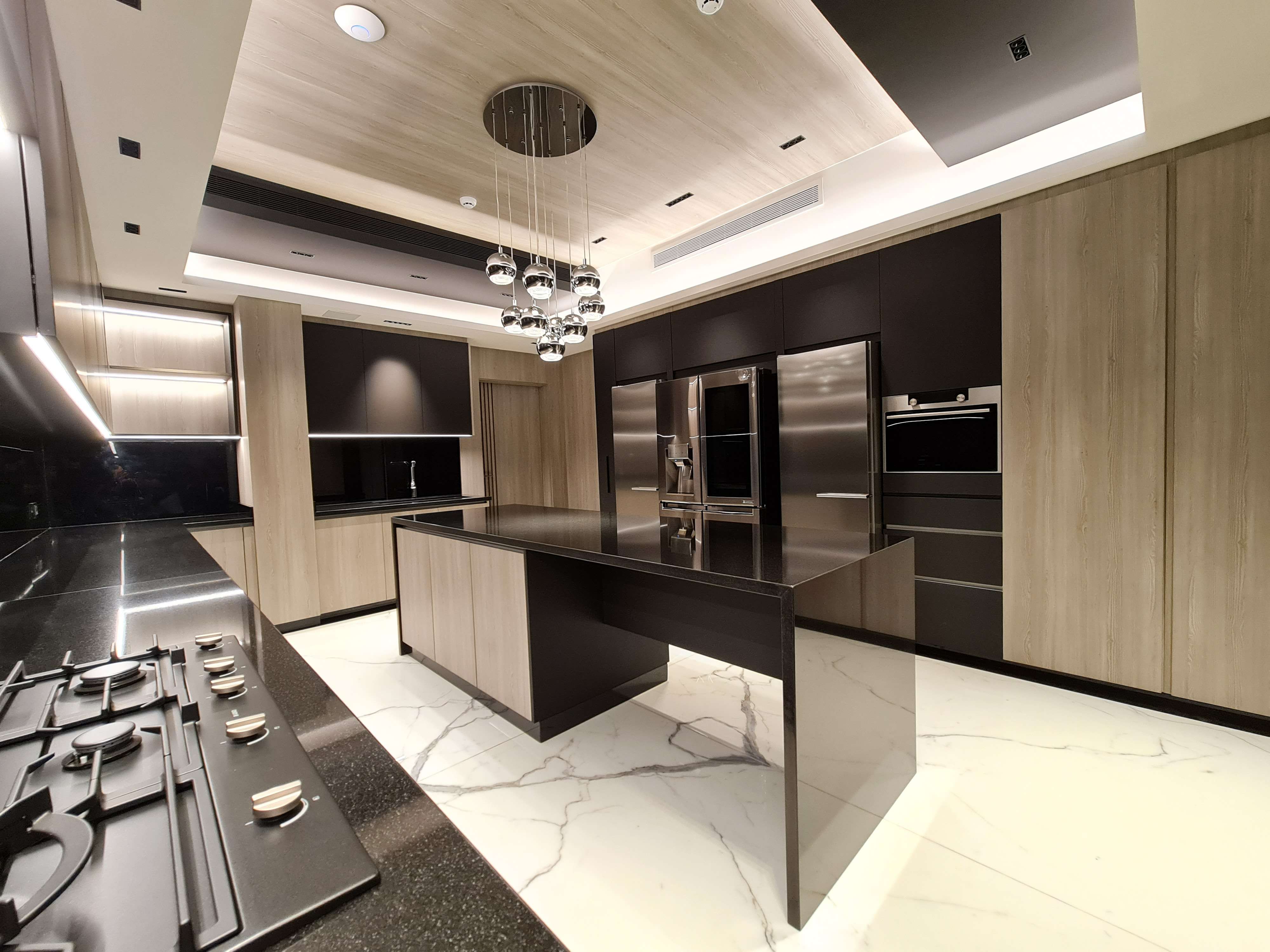 Bright kitchen with clean white cabinetry and high-end features by La Fabriqua